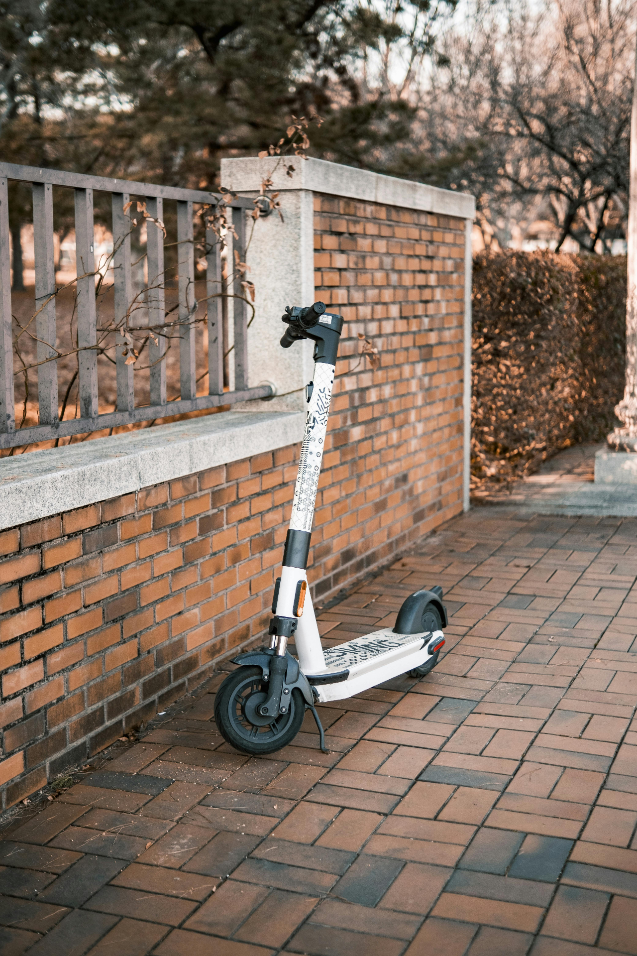 Elsparkcykel parkerad vid tegelvägg